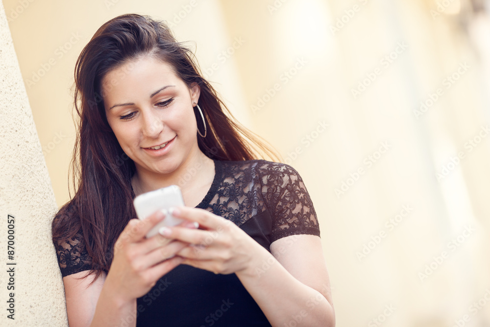 Young woman texting on her mobile phone Young woman texting on her mobile phone