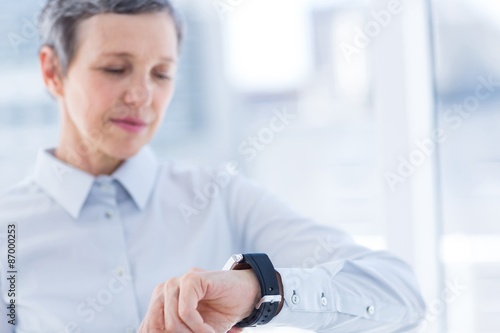 A businesswoman looking her smartwatch