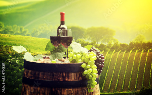 Fototapeta Naklejka Na Ścianę i Meble -  Red wine bottle and wine glass on wodden barrel. Beautiful Tusca