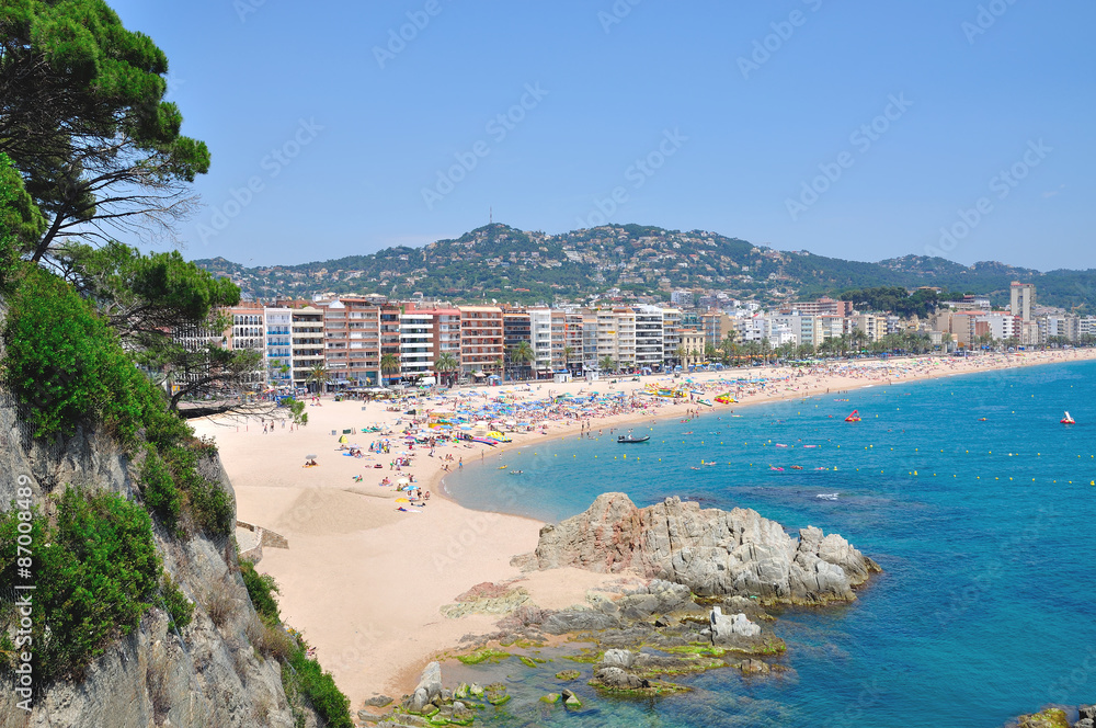 der Strand im beliebten Badeort Lloret de Mar an der Costa Brava in Spanien - obrazy, fototapety, plakaty 