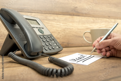 Closeup of male receptionist writing the word Urgent