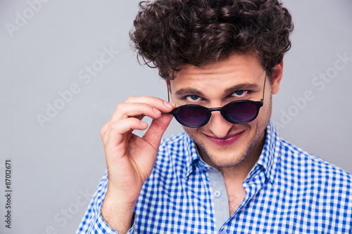 Man holding sunglasses and looking at camera