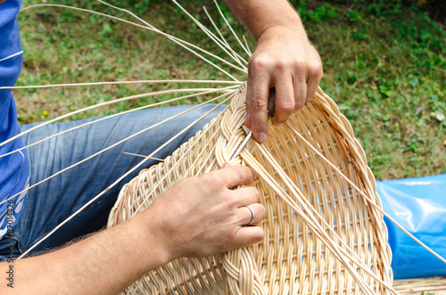 Man's hands making a wicker basket