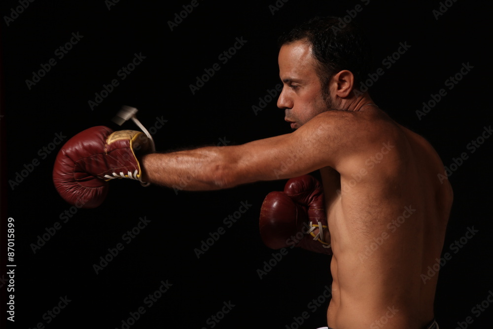 Man boxing over dark background