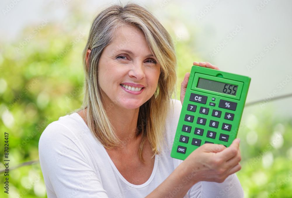 attractive smiling woman with calculator isolated on green background attractive smiling woman with calculator isolated on green background