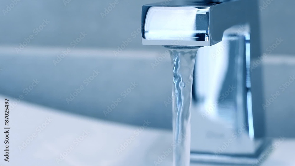 Open faucet in bathroom, water is running. Blue toned
Open faucet in bathroom, water is running. Blue toned