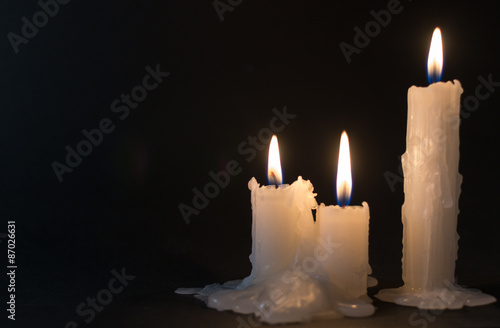 Three White Candles Burning at Night Time