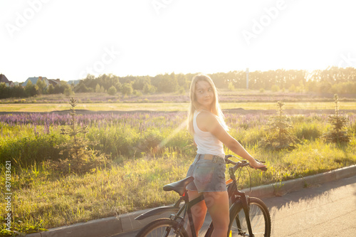 Young teen girl on bicycle in sunshine
