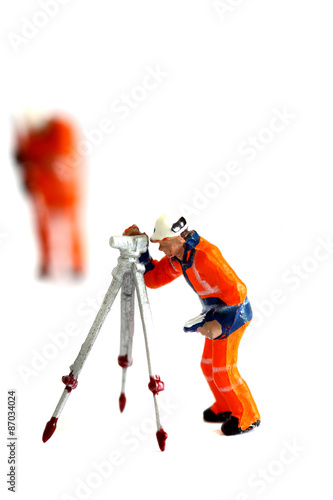 Miniature construction workers. Miniature scale model construction workers isolated on white background.