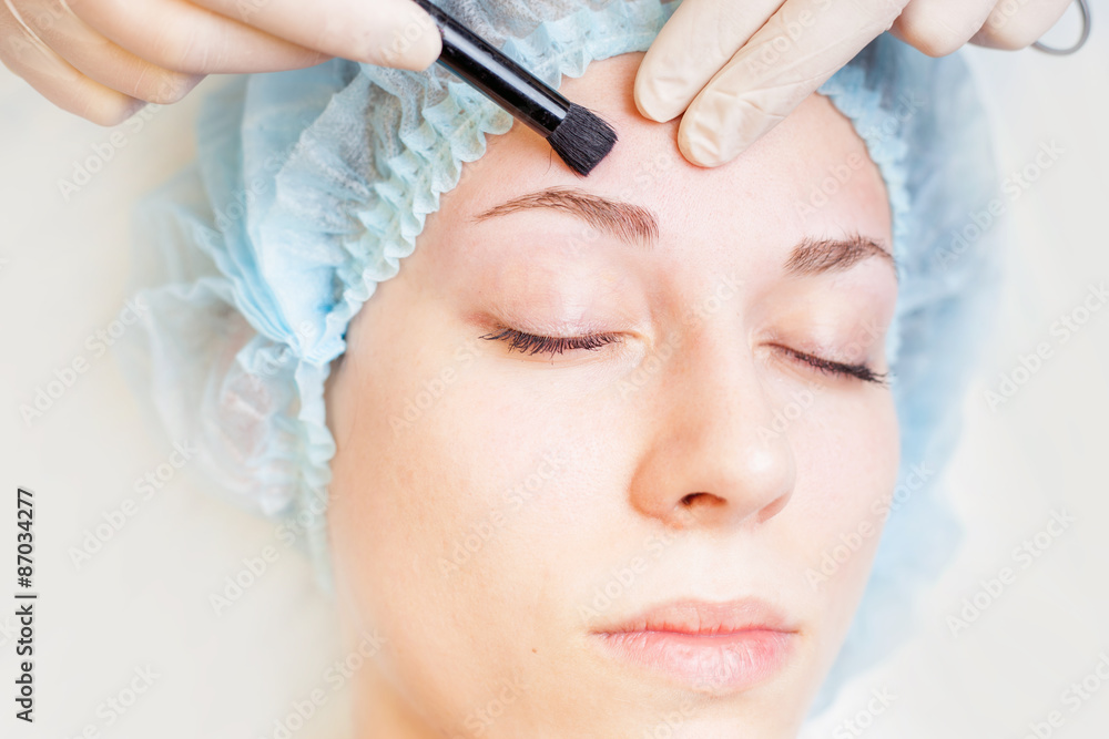 Professional woman at spa beauty salon doing correction eyebrow