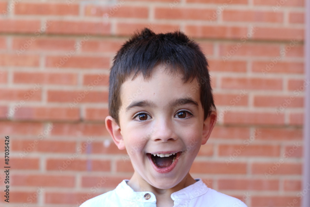 Portrait of boy surprised on brick wall background Portrait of boy surprised on brick wall background