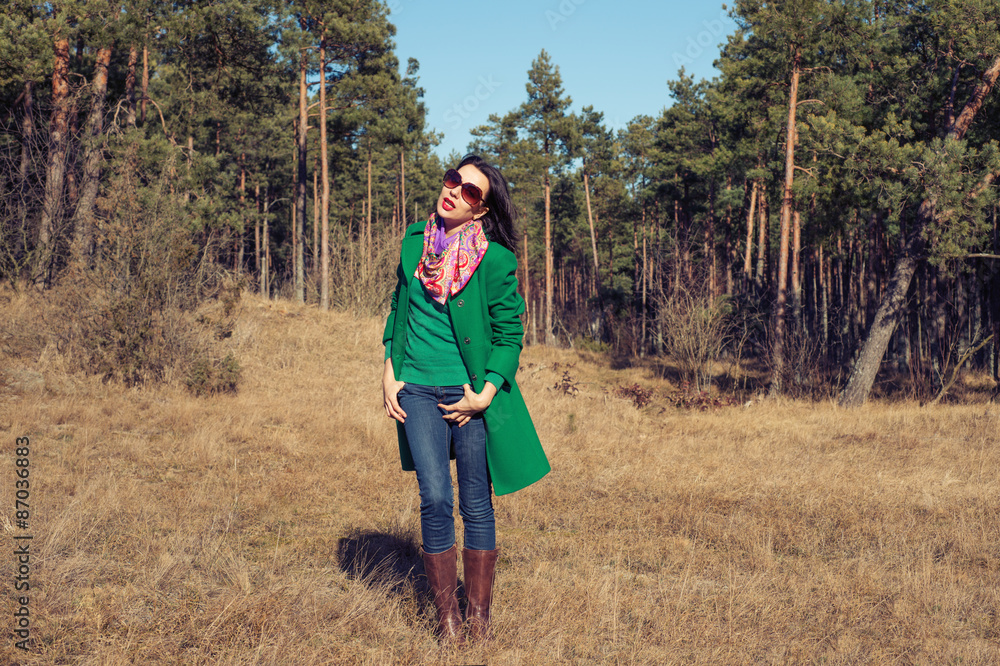 Woman in green coat walks on nature spring Woman in green coat walks on nature spring