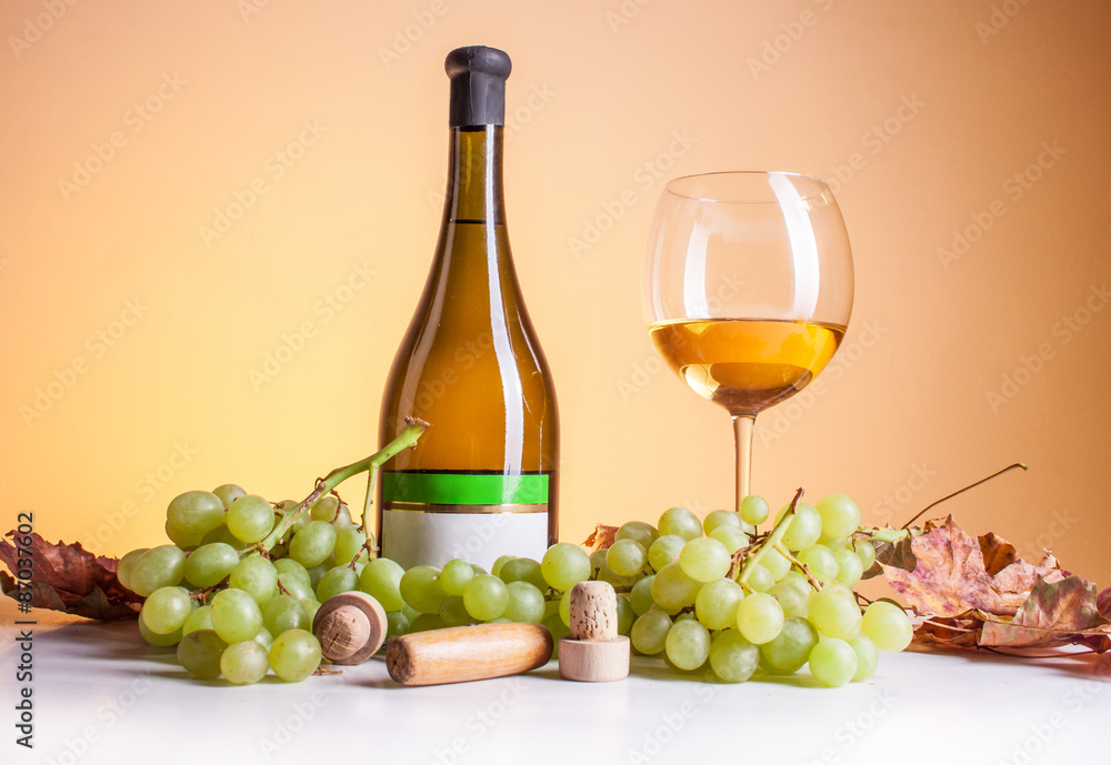 Obraz premium White wine in bottle and glass and a bunch of white grapes isolated on white