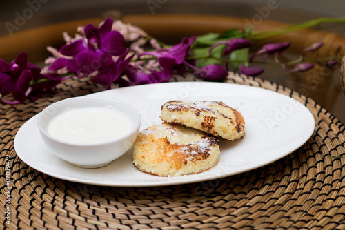 Syrniki, traditional Ukrainian and Russian cuisine. Cheese fritters with sour cream photo