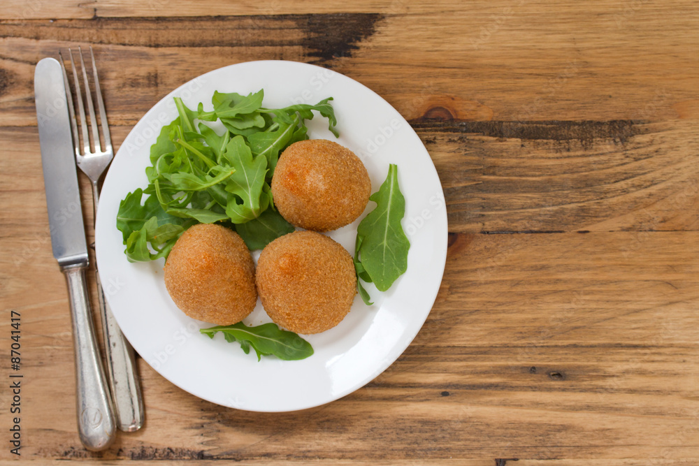 meat croquette on white plate on brown wooden background meat croquette on white plate on brown wooden background