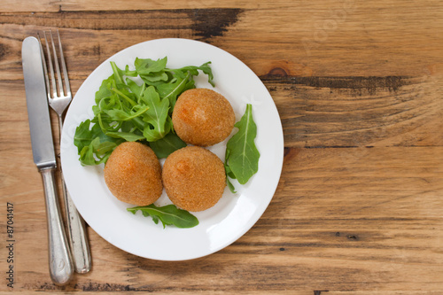 meat croquette on white plate on brown wooden background