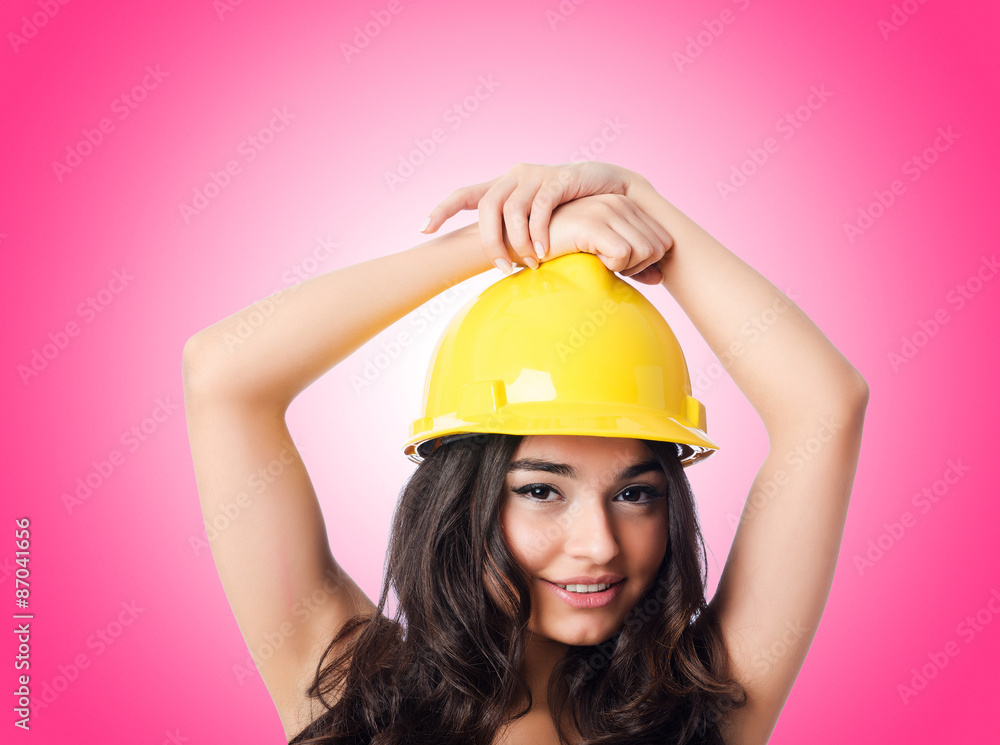 Young woman with hellow hard hat against gradient Young woman with hellow hard hat against gradient