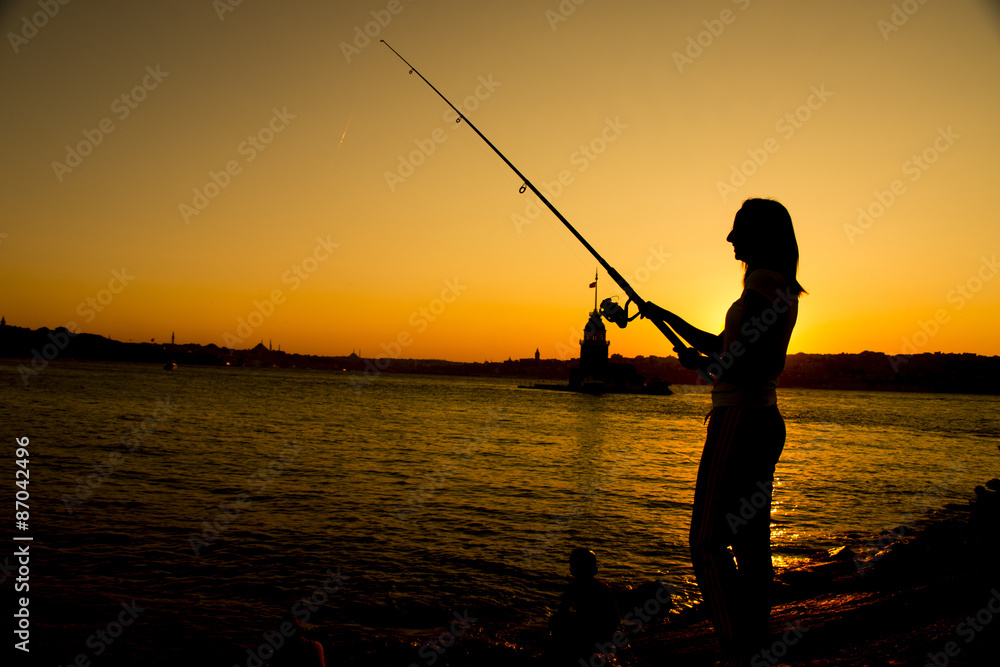 girl fishing at sunset