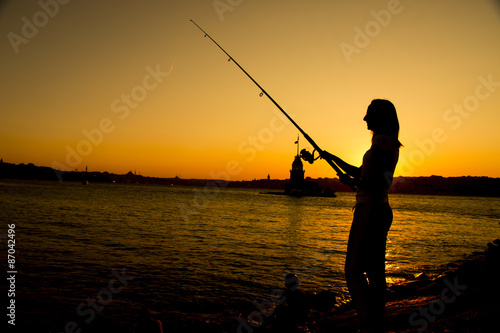 girl fishing at sunset