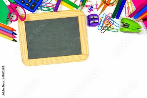 Blank chalkboard on a white background with school supplies top border