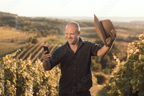 Foto Vineyard owner taking selfie with smart phone