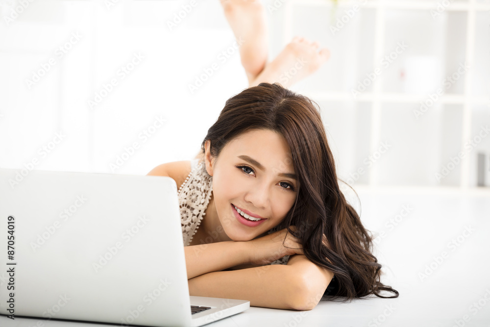 Happy pretty woman using laptop in living room Happy pretty woman using laptop in living room