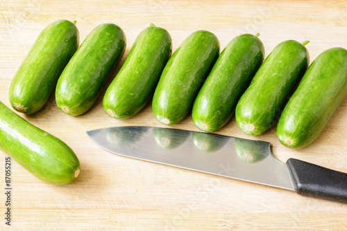 little cucumbers on the wooden board