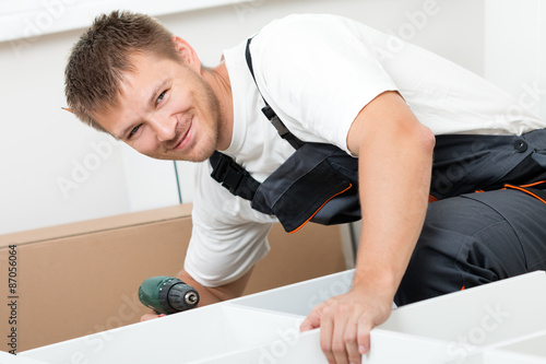 Man putting together self assembly furniture photo