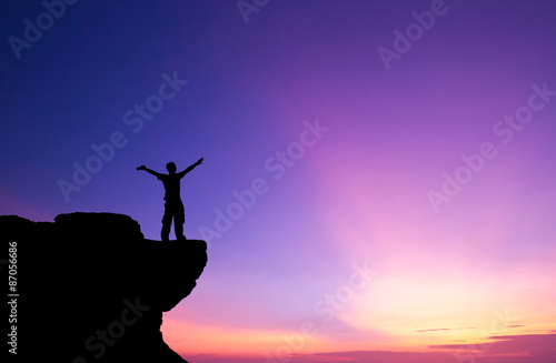 Silhouette of a man on the rock at sunset