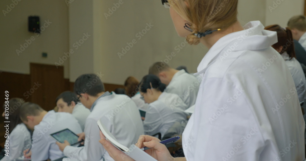 Girl medical student makes notes on the lecture Girl medical student makes notes on the lecture