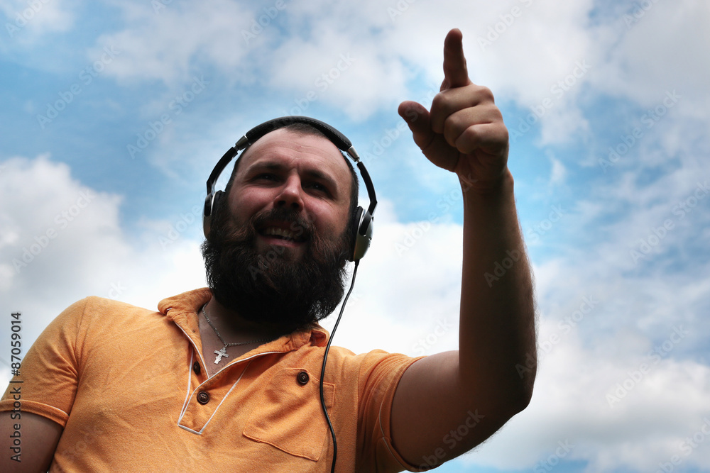 Fototapeta premium DJ with headphones on the sky background