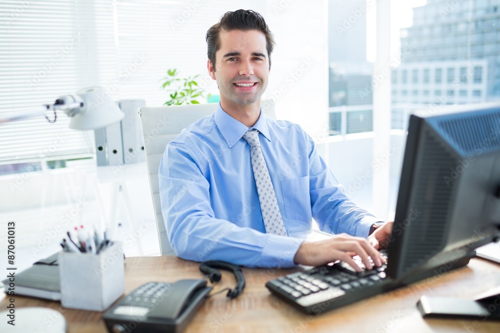 Smiling businessman using computer Smiling businessman using computer