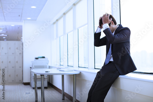 Depressed young businessman in office