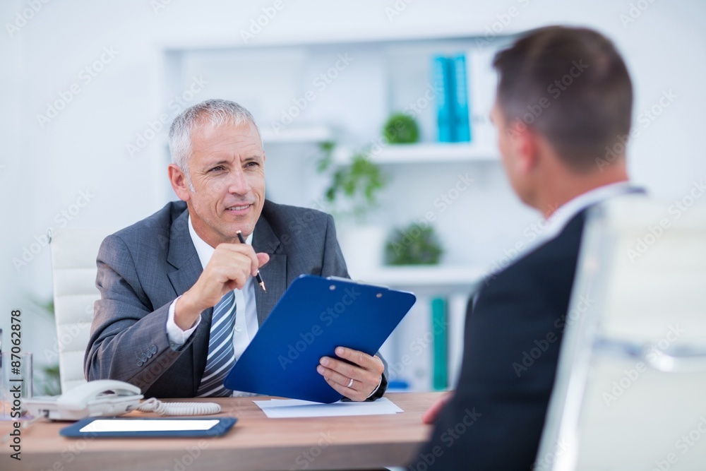 Two businessmen sitting and speaking and working Two businessmen sitting and speaking and working