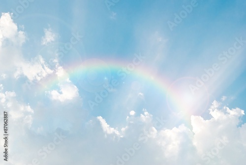 rainbow in the blue sky after the rain with lighting flare