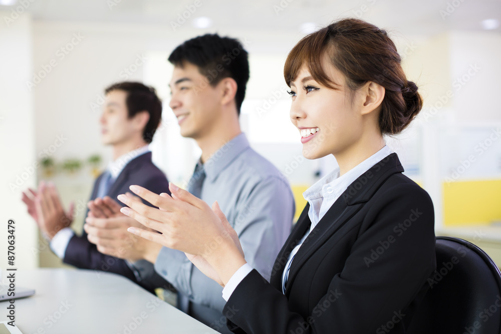 Business people sitting in a row and applauding Business people sitting in a row and applauding