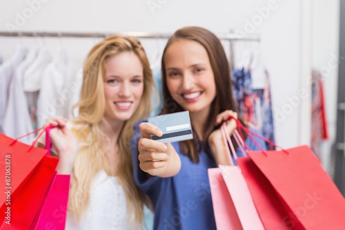 Happy friends handing a credit card