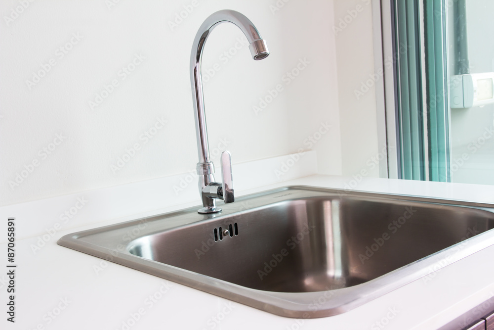 Water tap and sink in a modern kitchen. Water tap and sink in a modern kitchen.
