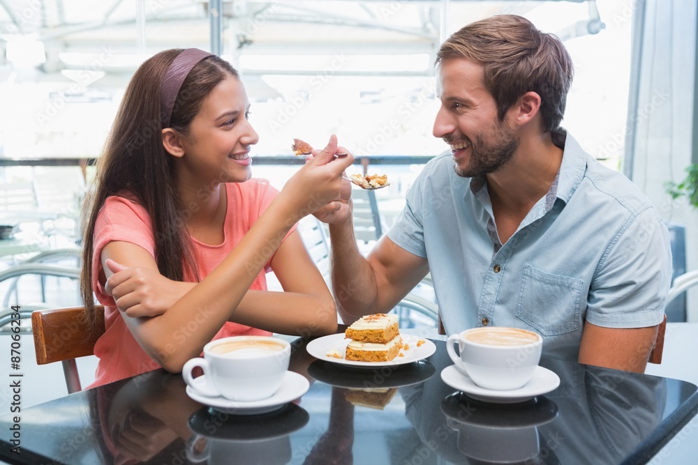 Young happy couple eating cake together Young happy couple eating cake together