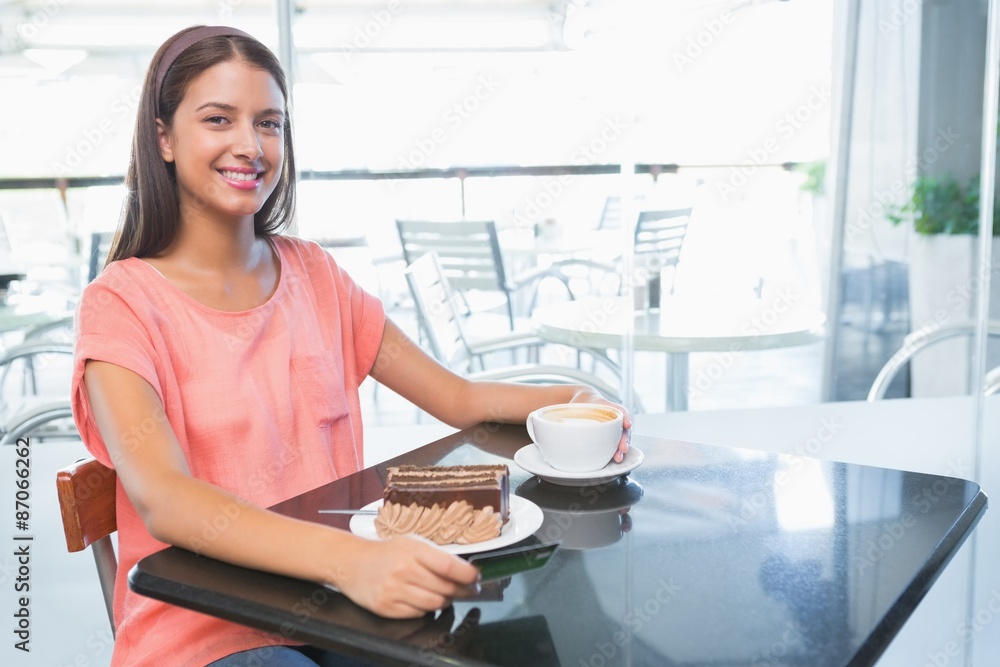 Young happy woman with cake and coffee
