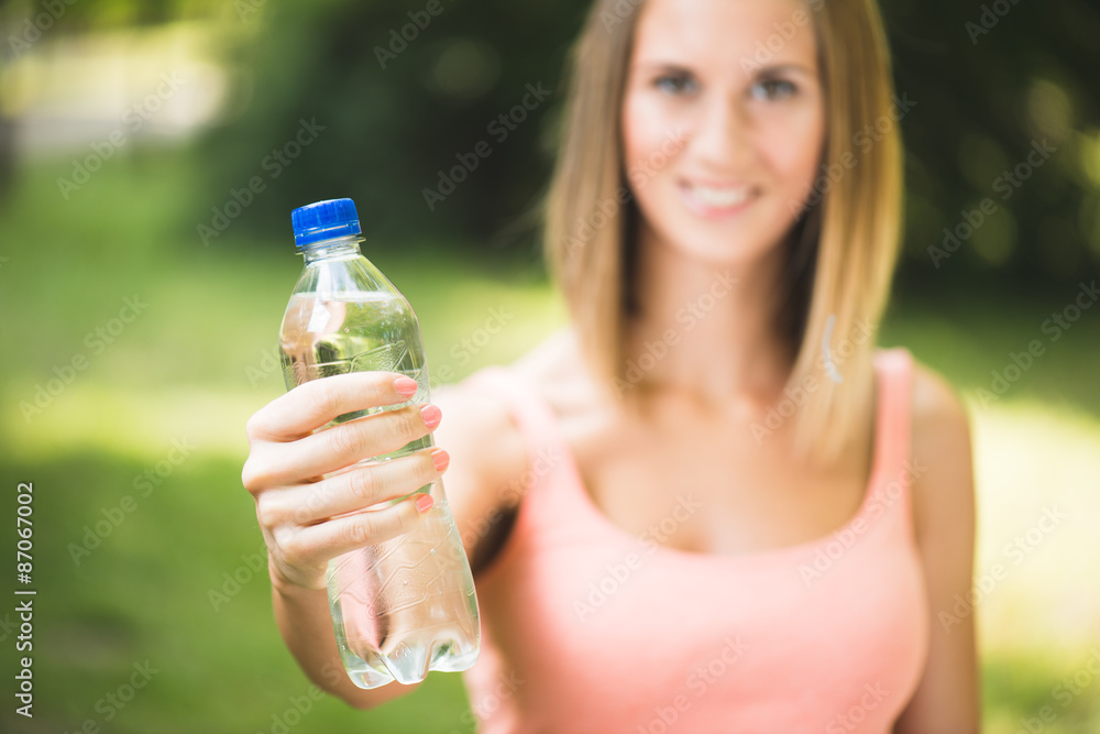 Beautiful young fitness woman holding water after working out Beautiful young fitness woman holding water after working out