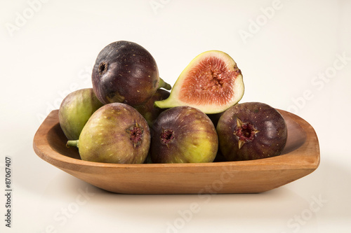 A couple of figs in a pot over a wooden table