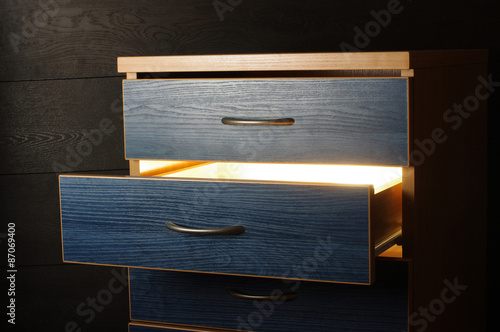 Billede på lærred Mystery concept light from open drawer in the darkness