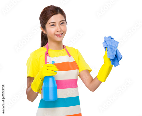 Young housewife clean with bottle spray and rag