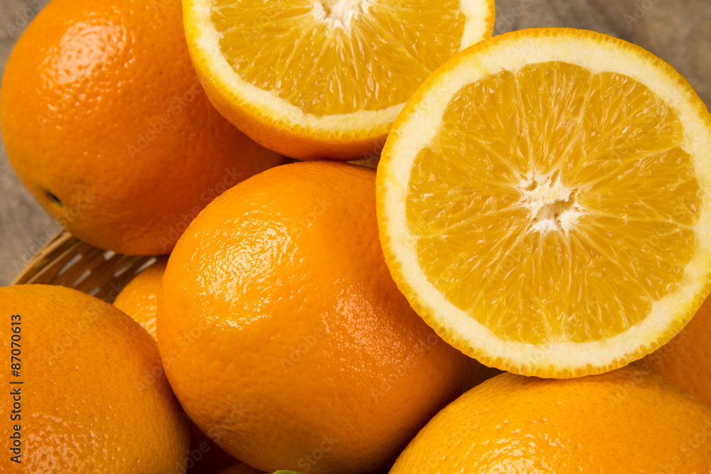 Close up of some oranges in a basket over a wooden surface Close up of some oranges in a basket over a wooden surface