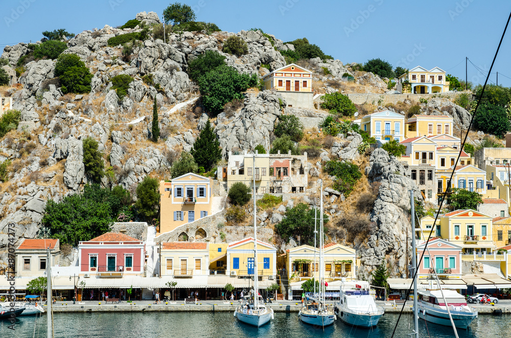 View of the yachts at the pier of the Symi island and houses
