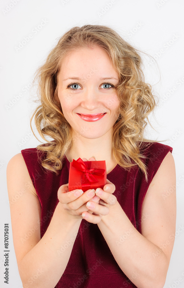 Close up of charming blonde girl standing with red gift box Close up of charming blonde girl standing with red gift box
