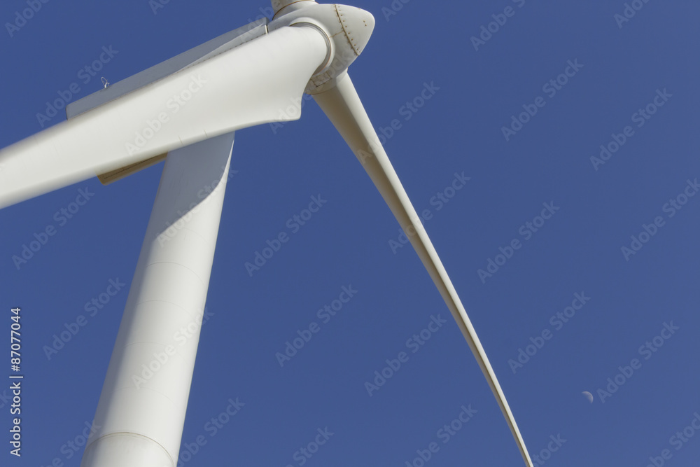Top of a windmill with daytime moon in the sky Top of a windmill with daytime moon in the sky