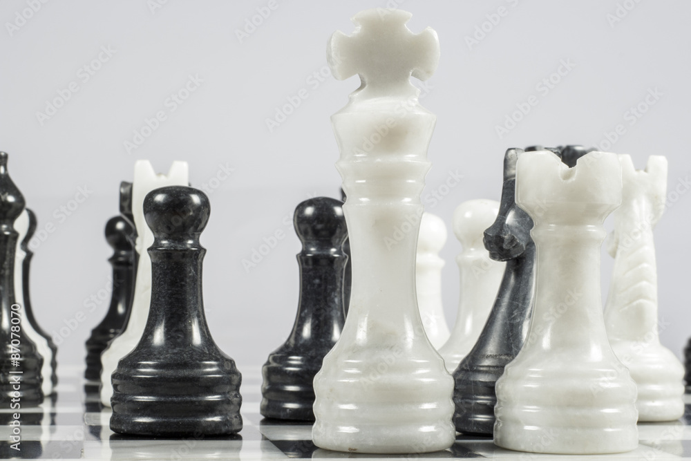 The white king falls under the checkmate of a black pawn. Marble pieces The white king falls under the checkmate of a black pawn. Marble pieces