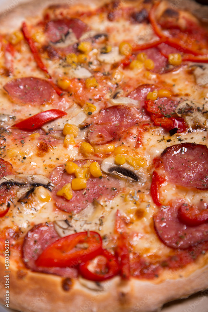 Tasty Italian pizza with pepperoni, corn and mushrooms